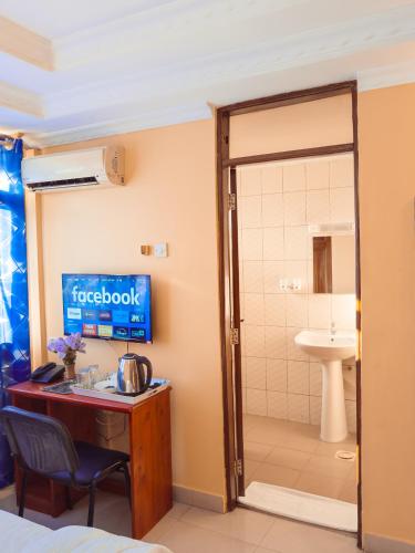 a room with a bathroom with a sink and a shower at Durban Hotel in Dar es Salaam