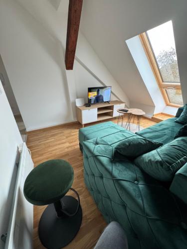a living room with a green couch and a chair at Central3 in Pančevo