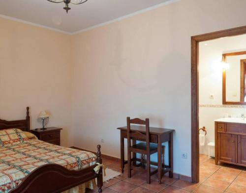 a bedroom with a bed and a desk and a sink at Casa Rural Vielba in Barruelo de Santullán