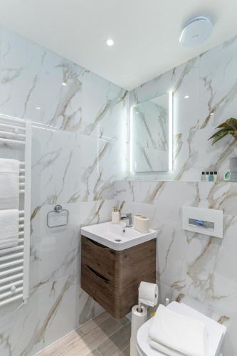 a white bathroom with a sink and a toilet at The Enchanting Silver Birch Retreat, New Forest in Ower