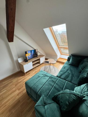a living room with a green couch and a tv at Central3 in Pančevo