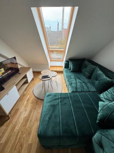 a living room with a green couch and a window at Central3 in Pančevo