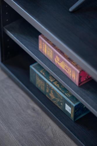 a stack of books sitting on a shelf at The Enchanting Silver Birch Retreat, New Forest in Ower
