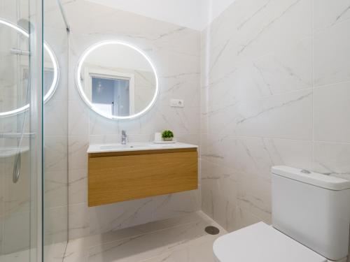 a white bathroom with a sink and a mirror at Refurbished 2 bedrooms house private pool in San Bartolomé de Tirajana