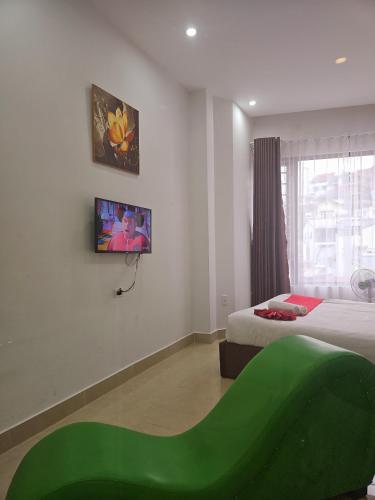 a room with two beds and a green couch at Love Hotel - Khách Sạn Theo Giờ in Da Lat