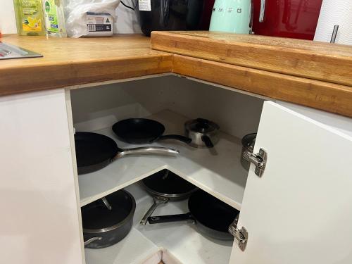 a kitchen drawer with pots and pans in it at OneWorldLove Garden in Woy Woy