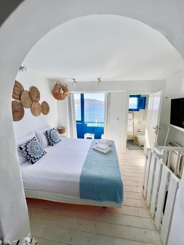 a bedroom with a bed and a view of the ocean at Kyma Apartments-Little Venice,Mykonos in Mikonos
