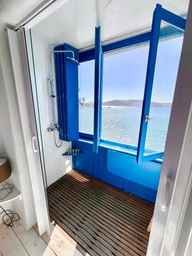 a bathroom with a blue door and a window at Kyma Apartments-Little Venice,Mykonos in Mikonos