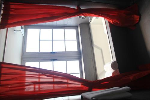 a window in a room with a red bedspread at Leslie Hotel Ocean Drive in Miami Beach