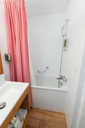 a bathroom with a bath tub and a shower curtain at Hotel Bernerhof Grindelwald in Grindelwald