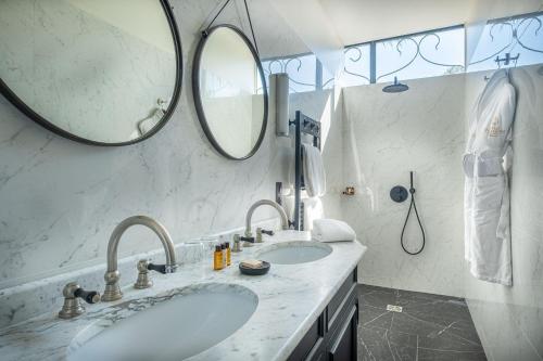 a bathroom with two sinks and two mirrors at La Villa Mauresque in Saint-Raphaël