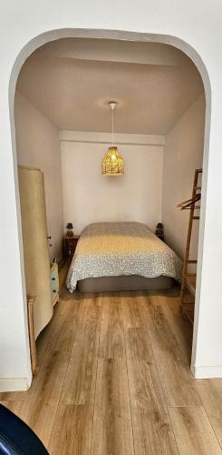 - une chambre avec un lit dans une pièce avec une arche dans l'établissement T2 au coeur de Bayonne, à Bayonne