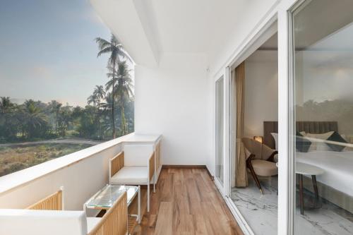a room with a balcony with a view of the ocean at White Wharf Beach Resort Morjim Goa in Morjim