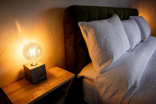 a lamp on a night stand next to a bed at Felim's Place in Doolin