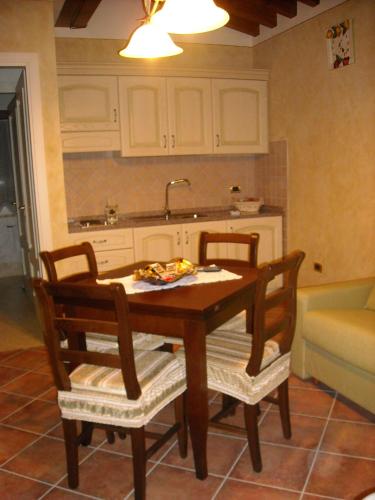 a kitchen with a wooden table and two chairs at Appartamenti Roberta Cisanello in Pisa