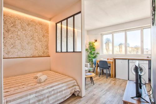 une chambre avec un lit et un bureau dans une pièce dans l'établissement Le Nid - Hypercentre - Vue sur le Château, à Caen