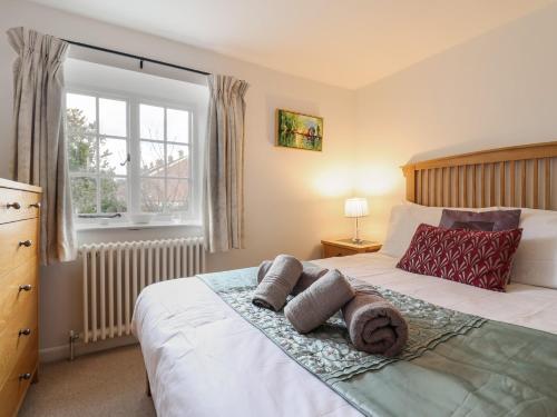 a bedroom with a bed with towels on it at Old Ropemakers Cottage in Bridport