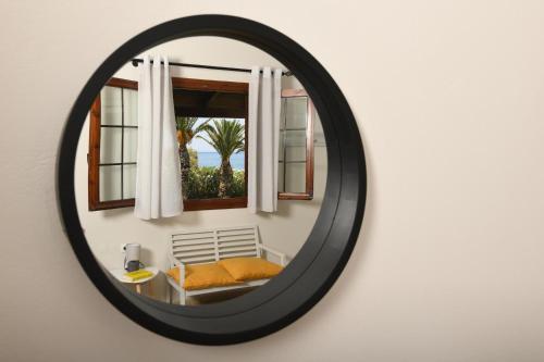 a mirror hanging on a wall with a window at Kotsoris Studios in Kyparissia