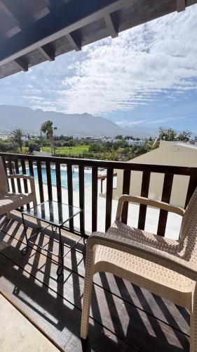 two chairs on a balcony with a view of the ocean at The Horse Farm Hotel in Kérynia