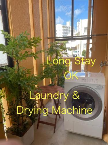 a washing machine sitting in a room with plants at Yellow House Okinawa in Naha