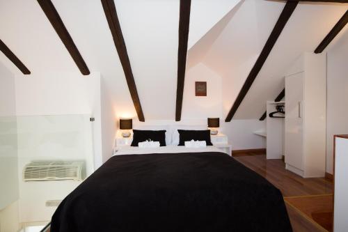 a bedroom with a large black bed in a attic at Casa Arancia in Dubrovnik
