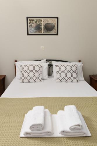 a bedroom with a bed with white towels on it at Kotsoris Studios in Kyparissia