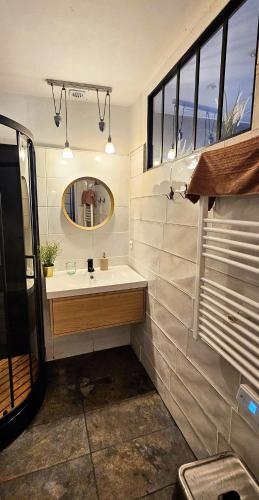 une salle de bain avec un lavabo et un miroir dans l'établissement T2 au coeur de Bayonne, à Bayonne