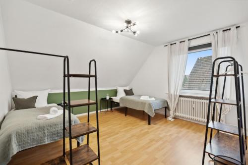 イゼンビュッテルにあるAPARTMENT in Isenbüttel - 90m2, 3 Zi, 5 Einzelbetten, Free Coffee, WiFi & Parking - 24h CHECK INのベッドと窓のある白い寝室
