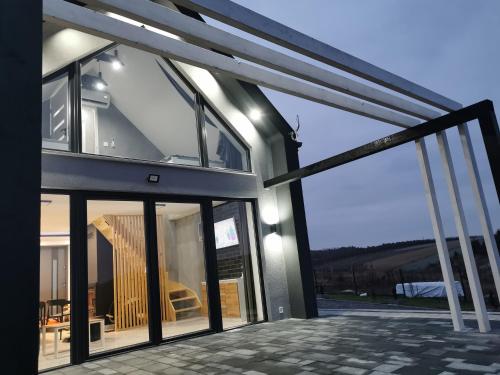 a house with glass doors and a balcony at Ponad Niebem in Chańcza