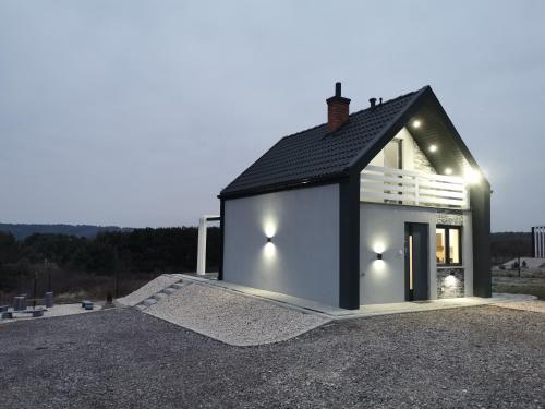 a small white house with a black roof at Ponad Niebem in Chańcza