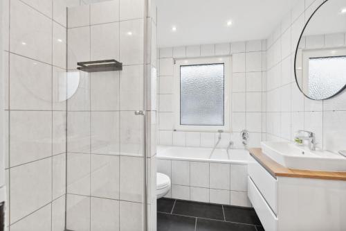 イゼンビュッテルにあるAPARTMENT in Isenbüttel - 90m2, 3 Zi, 5 Einzelbetten, Free Coffee, WiFi & Parking - 24h CHECK INのトイレと洗面台を備えた白いバスルーム