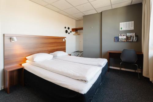 a bedroom with a large bed with a wooden headboard at Hotel Sverre in Sandnes
