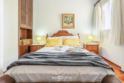 a bedroom with a large bed with two night stands at Lindo Condomínio com Lazer em Poços de Caldas - QUI in Poços de Caldas