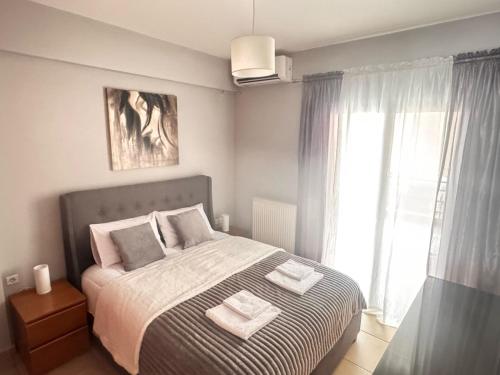a bedroom with a bed with two towels on it at Olga apartment in Chalkida