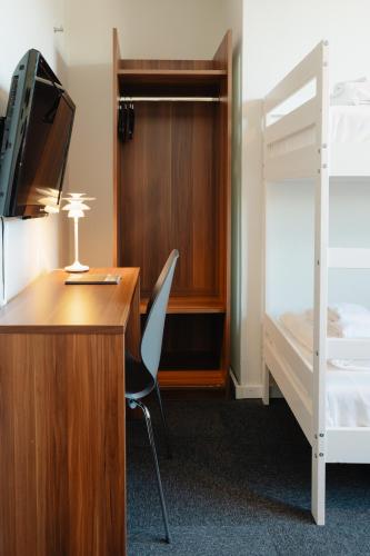 a room with a desk and a bed and a bunk bed at Hotel Sverre in Sandnes