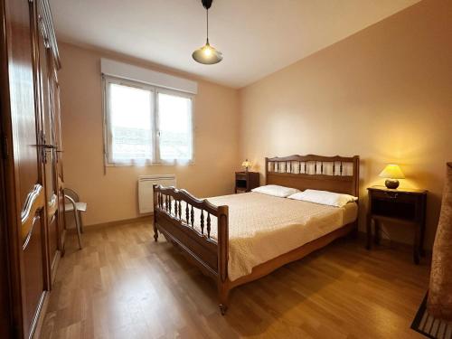 une chambre avec un lit en bois et une fenêtre dans l'établissement Appartement confortable aux Sables-d'Olonne de 61 m², à Les Sables-dʼOlonne