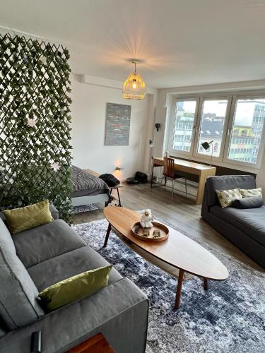 a living room with a couch and a table at Stillvolles Apartment mitten in little Tokyo in Düsseldorf