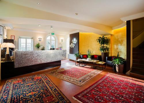 a living room with a couch and a rug at Hotel Hambros - Il Parco in Villa Banchieri in Lucca