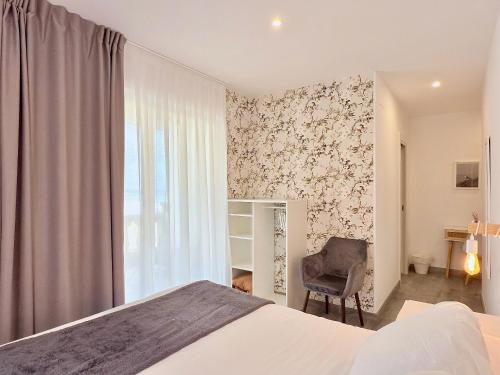 a bedroom with a bed and a chair and a window at Hotel SanMar in Cóbreces