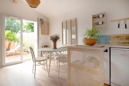 une cuisine et une salle à manger avec une table et des chaises dans l'établissement Jolie maison face à l'océan Biscarrosse Plage, à Biscarrosse