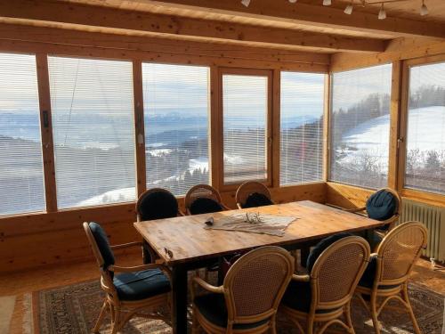 a dining room with a table and chairs and windows at Mountain house with a view in Christofberg