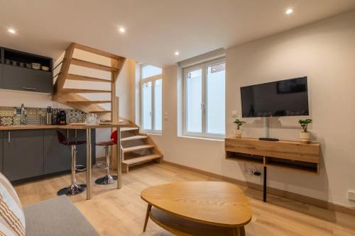 a small living room with a tv and a table at Duplex une chambre calme, proche commodités in Lille