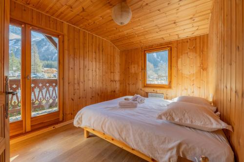 Ce lit se trouve dans une chambre en bois dotée d'une fenêtre. dans l'établissement Chalet Grands Montets -Garden -Ski in out - Happy Rentals, à Chamonix-Mont-Blanc