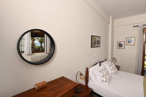a bedroom with a bed and a mirror on the wall at Kotsoris Studios in Kyparissia