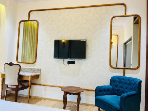 a room with a blue chair and a mirror at Hotel Virasat-E-Bushahr in Rāmpur