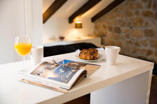 a table with a plate of food and a glass of orange juice at Casa Arancia in Dubrovnik
