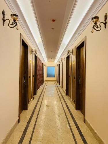 a corridor of a building with wooden doors and a long hallway at Hotel Virasat-E-Bushahr in Rāmpur