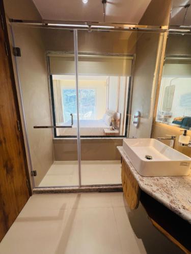 a bathroom with a shower and a sink at Hotel Virasat-E-Bushahr in Rāmpur