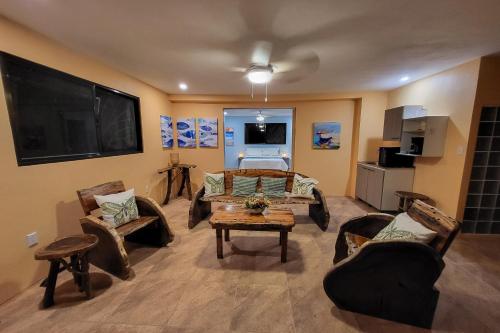 a living room with furniture and a flat screen tv at Casa Garrobo in Dominical