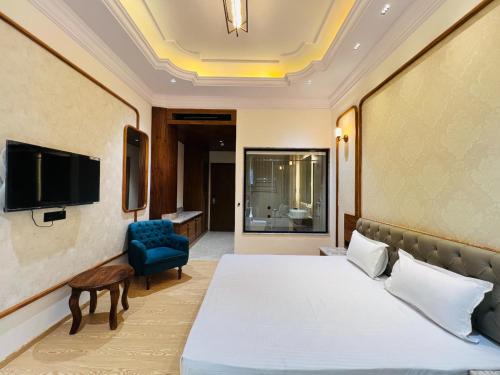 a hotel room with a bed and a chair at Hotel Virasat-E-Bushahr in Rāmpur